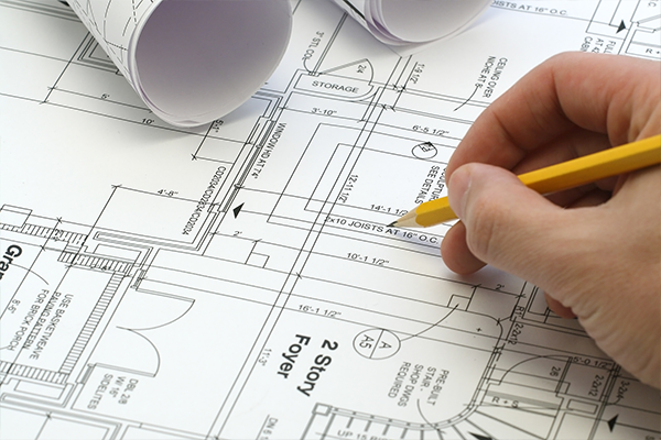 An image of person using a pencil to point at a blueprint of a house